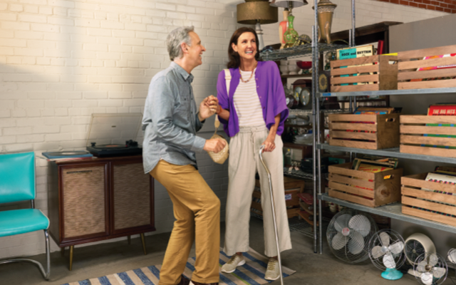 A couple is spontaneously dancing together in a thrift store.